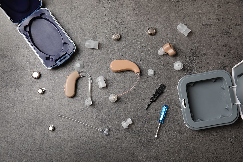 Closeup of hearing aids and accessories on grey background